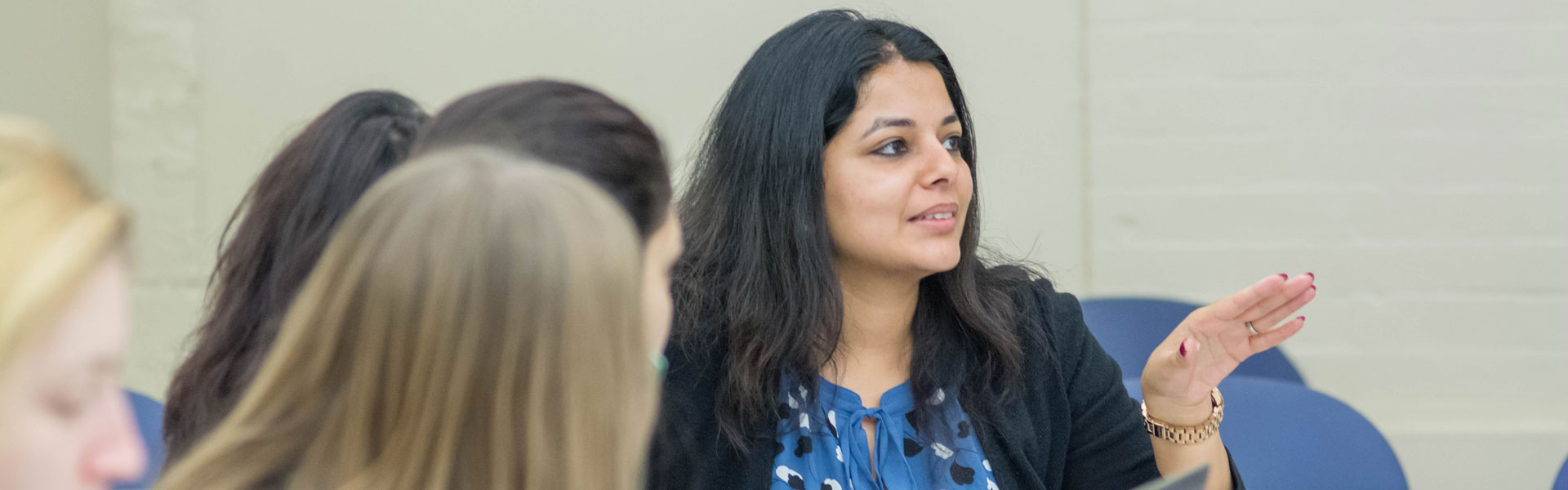 A woman having a discussion in a classroom.
